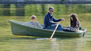 Young family in a boat on a park lake